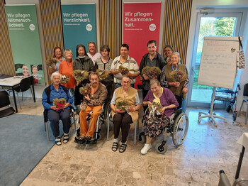 Gruppenfoto im Haus Maria in Bleiburg mit selbst gestalteten Duftherzen aus Heu und Kräutern zum Weltalzheimertag.