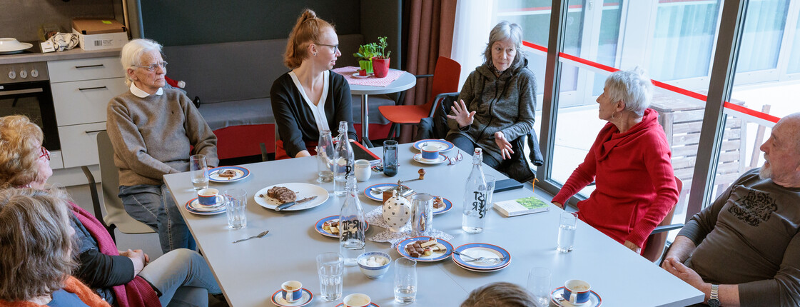 Angehörige sitzen mit Kaffee und Kuchen bei einem Angehörigencafé zusammen.