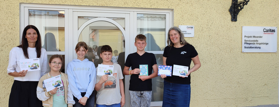Szenerie: Schulkinder übergeben einen Scheck