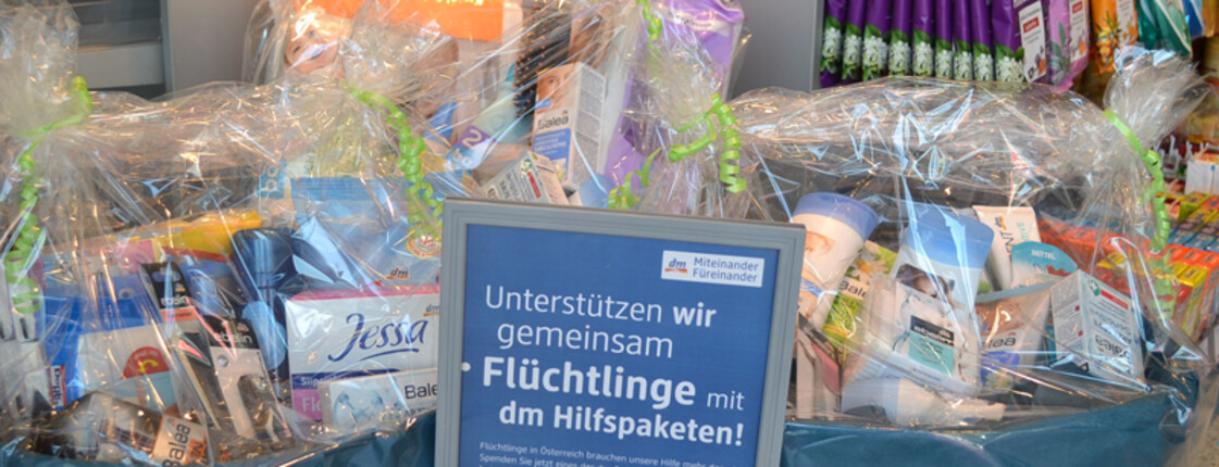 Hygienepakte im Wert von 5, 10 bzw. 20€ , die unterschiedliche Produkte wie Duschgeel und Shampoo beinhalten, stehen schön verpackt in einem Drogeriemarkt. Sie werden Flüchtlingen im ganzen Land unterstützen. 