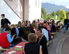 Zahlreiche Leute sitzen im Freien auf Bänken beim langen Tag der Flucht.