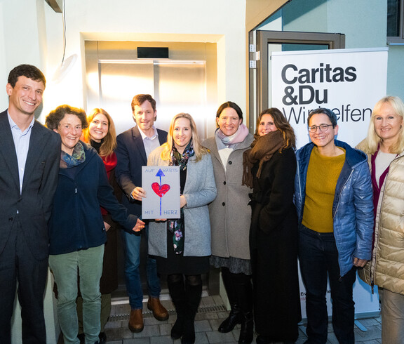 CEO Louis Kahane mit Mitarbeiter*innen der Bank Gutmann AG und Caritas-Mitarbeiter*innen vor dem neuen Lift. © Stefanie Steindl