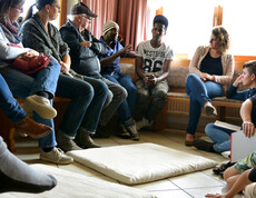 Ein Bild mit Menschen und Flüchtlingen, die alle miteinander sprechen.