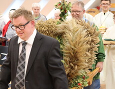 Zwei Männer tragen eine Erntekrone