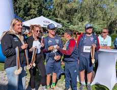 Hannah Ladinig und Mitglieder der KUGIS präsentieren Finisher-Medaillen beim Charity Run in Friesach.
