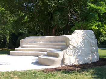 Ein weißes Auditorium im Park, auf dem man dem inklusiven Konzert im Park lauschen kann.