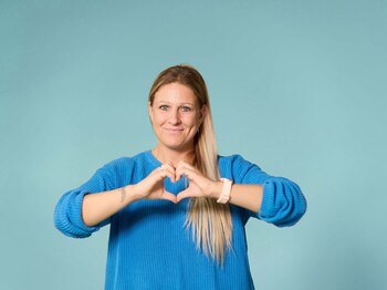 Dame, die mit den Händen ein Herz formt