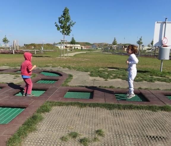 Zwei Kinder bewegen sich über eine Trampolinanlage im Motorikpark und fördern spielerisch Koordination sowie Gleichgewicht.