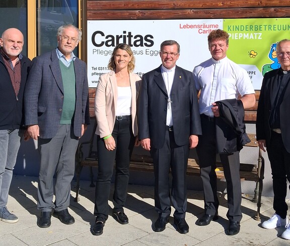 Gruppenfoto vor dem Eingang des Caritas Pflegewohnhauses Eggersdorf: Sechs Personen stehen vor einer Tafel mit dem Schriftzug „Caritas Pflegewohnhaus Eggersdorf“ und dem Logo des Kinderbetreuungsvereins Piepmatz.