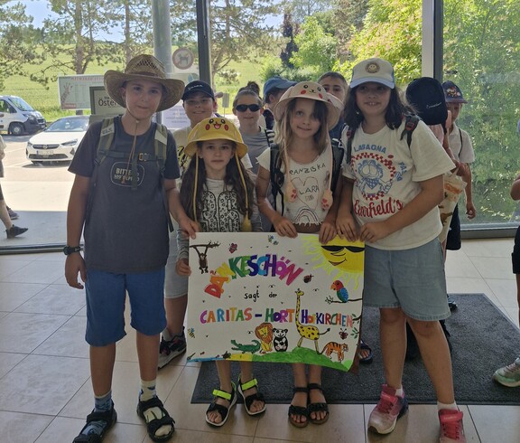 Kinder halten im Eingangsbereich vom Zoo ein Danke-Plakat in den Händen.
