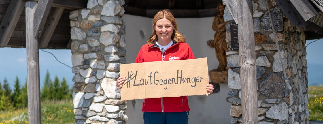 Caritas Österreich-Präsidentin Nora Tödtling-Musenbichler hält ein Schild mit dem Wortlaut "LautGegenHunger"