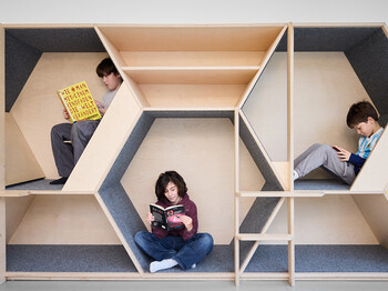 Drei Schüler*innen lesen in modularer Lernecke aus Holz mit individuellen Rückzugsorten