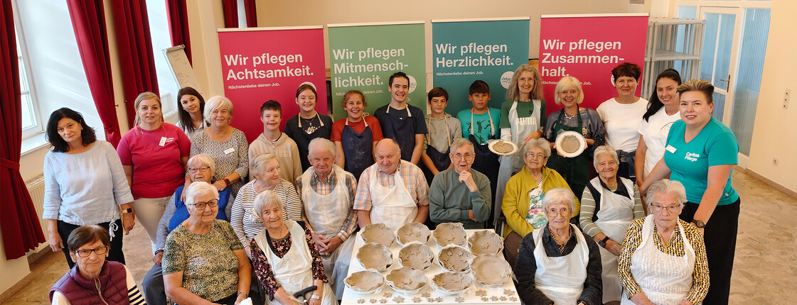 Gruppenfoto im Haus Elisabeth in St. Andrä mit Besucher*innen und Bewohner*innen beim kreativen Arbeiten mit Ton.