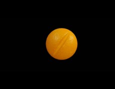 Dieses Bild zeigt eine orange Pille mit Bruchrille.