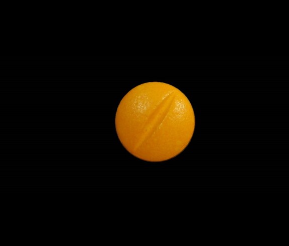 Dieses Bild zeigt eine orange Pille mit Bruchrille.