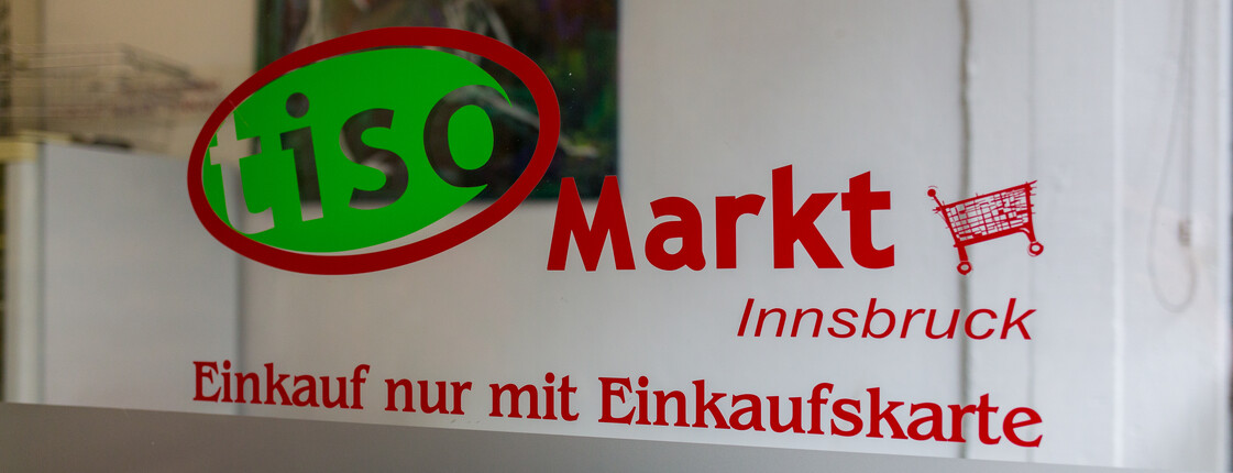 Ein Schaufenster mit dem offiziellen Logo des Tiroler Sozialmarktes.