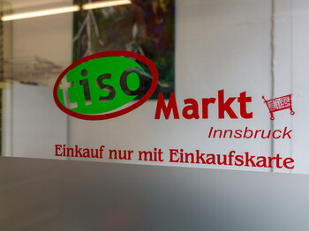 Ein Schaufenster mit dem offiziellen Logo des Tiroler Sozialmarktes.