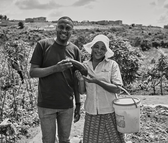 Zwei lachende Menschen mit Gemüse