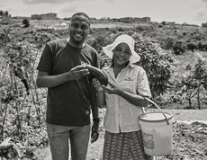 Zwei lachende Menschen mit Gemüse