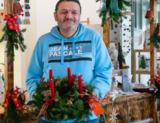 Mann hat Adventkranz in der Hand