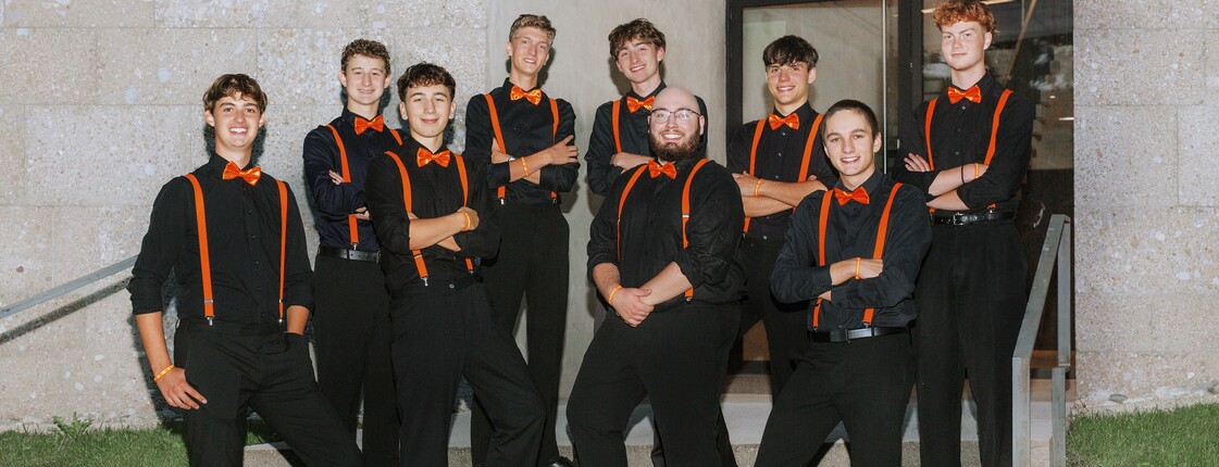 Neun junge Männer stehen auf einer Treppe