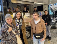 Mitglieder der Inklusiven Redaktion und SOB-Leitung Conny Zefferer vor dem Speisewagen der Caritas OÖ beim Inklusionstag der Stadt Linz 2025