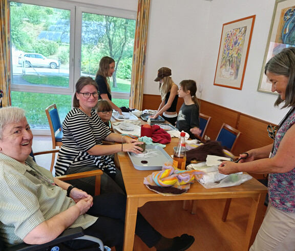 Kinder, Erwachsene und Senior*innen gestalten gemeinsam Filzarbeiten im Festsaal
