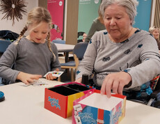 Kind und Senior*in spielen gemeinsam das Spiel „Speed Cups“