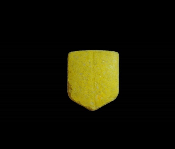 Das Bild zeigt eine gelbe Pille in UPS-Logo Form mit Bruchrille