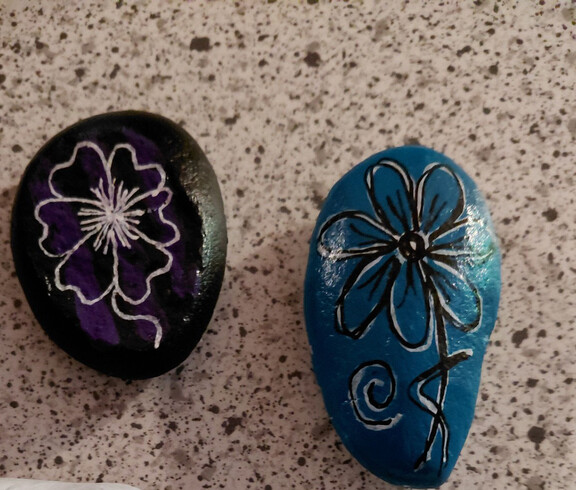 Zwei bemalte Steine mit einem Blumenmotiv