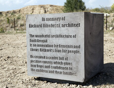 Auf einem Boden befindet sich ein dicker grauer Stein, der bedruckt ist. Der Gedenkstein bezieht sich an Richard Nikolussi, einen Architekten. 