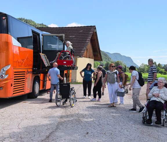 Bewohner*innen und Mitarbeitende steigen bei einem barrierefreien Reisebus aus, Rollstuhllift im Einsatz.