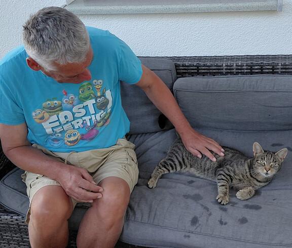 Mann und Katze auf Couch 