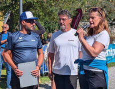 Drei Personen, darunter Caritasdirektor Ernst Sandriesser, sprechen vor dem Startbereich des Charity Runs mit Publikum im Hintergrund.