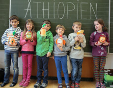 Sechs Volksschulkinder präsentieren ihre Bastelfiguren vor einer Tafel. Auf der Tafel ist mit großer Schrift Äthiopien zu lesen.