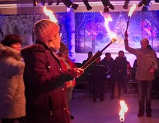 Mehrere Menschen jonglieren mit brennenden Fackeln.