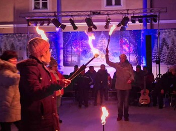 Mehrere Menschen jonglieren mit brennenden Fackeln.