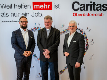 Drei Männer stehen vor einem Werbeplakat