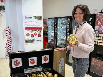 Eine Frau hält eine Christbaumkugel in der Hand