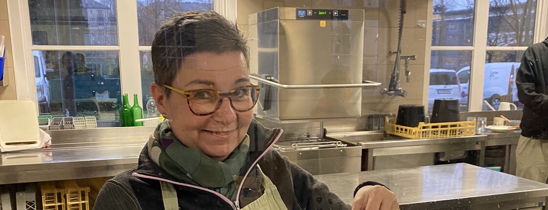 Foto der freiwilligen Mitarbeiterin Birgit, auf dem sie Kaffee ausschenkt. 