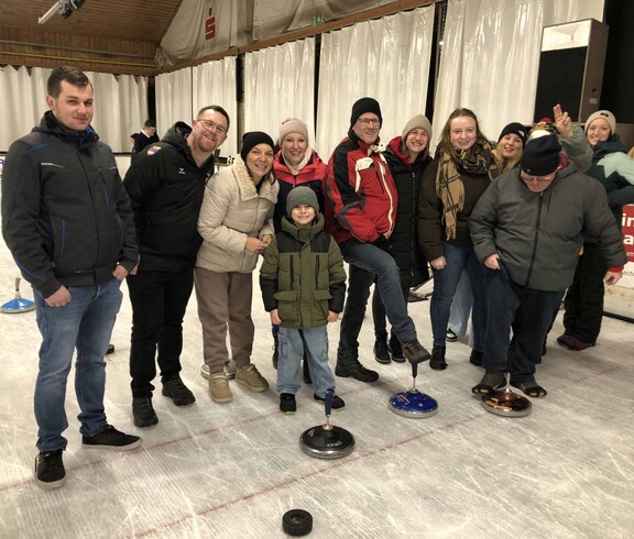 Viele Stockschützen mit ihren Eisstöcken in der Eishalle