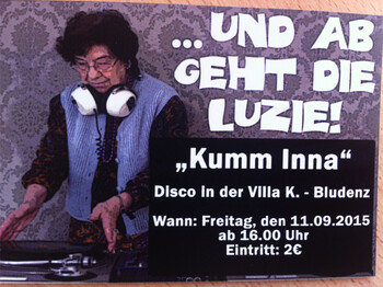 Integrative Disco Plakat. Eine Frau mittleren Alters steht an einem Mischpult. Sie hat weiße Kopfhörer und trägt ein blaues Jackett. Die Schrift ist weiß. 