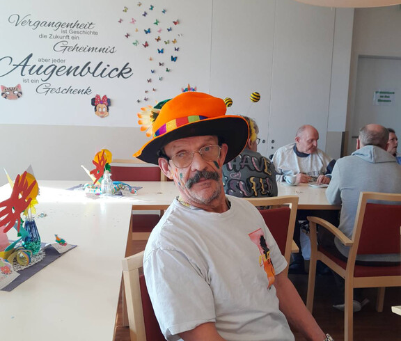 Mann mit Blumenhut