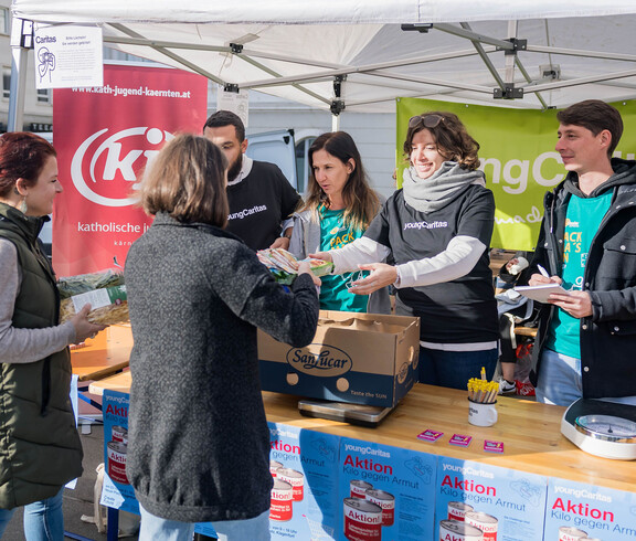 Helfer*innen der youngCaritas und Katholischen Jugend nehmen gespendete Produkte am Sammelstand entgegen.