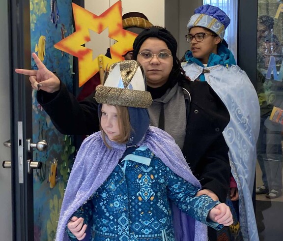 Drei Kinder als Sternsinger verkleidet mit einem gelben Stern.