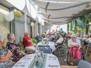 Festlich gedeckte Terrasse mit Gästen und Bewohner*innen beim Sommerfest im Haus Maria.