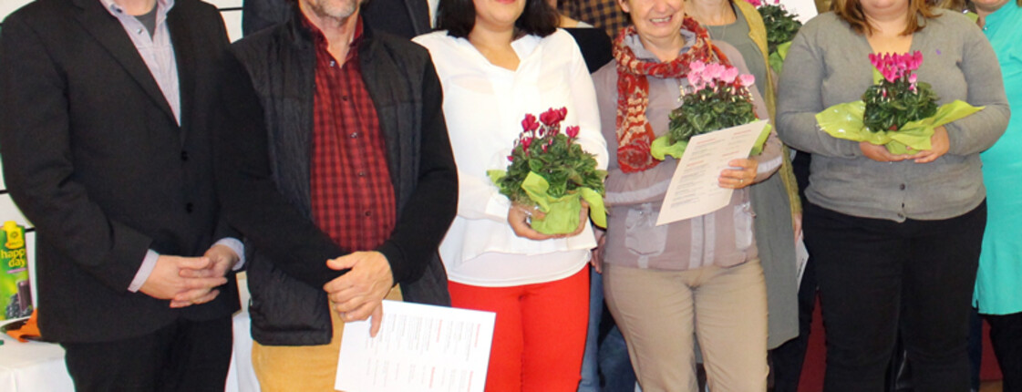 Gruppenfoto der Sozialpaten mit Peter Klinger. Sie alle sind modisch schick angezogen in ganz unterschiedlichen Farben. Manche Personen haben Blumen in den Händen. 
