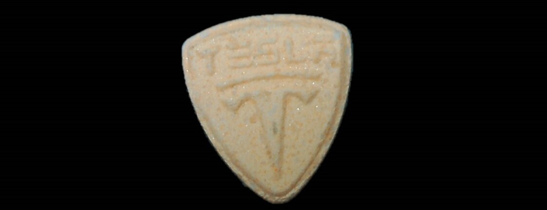Dieses Bild zeigt eine orange Pille (Logo Tesla).
