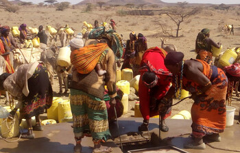 Afrikaner*innen holen gemeinschaftlich Wasser aus den Tiefen Brunnen, während im Land eine Dürre herrscht.