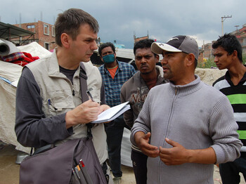 Caritas Helfer Andreas Zinggl unterhält sich in Kathmandu mit Einwohnern.